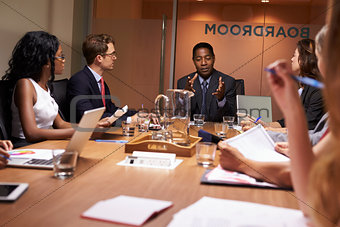Businessman addressing colleagues at a meeting, close up