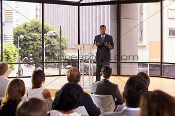 Black businessman presenting seminar gesturing to audience