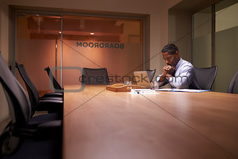 Middle aged black businessman works on laptop late in office