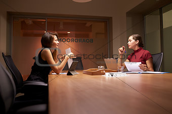 Two female business colleagues working late in an office