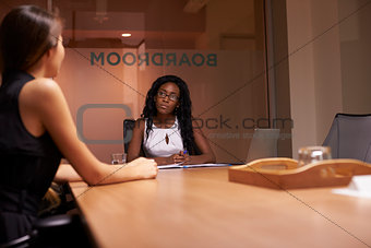 Two corporate businesswomen at an evening meeting in office