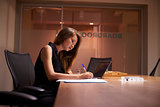 Young Asian businesswoman working alone late in an office