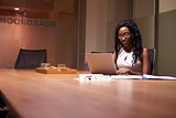 Young black businesswoman working late on laptop in office