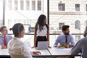 Young businesswoman and colleagues at meeting, looking away