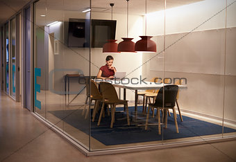 Businesswoman working alone in cubicle at corporate business