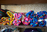 Colourful blankets on shelves in store, close up, front view