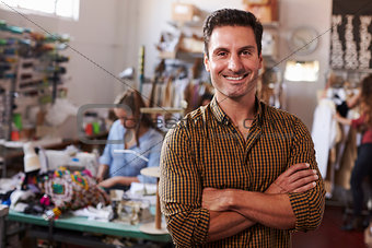 Male business owner in clothing design studio, arms crossed