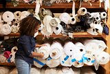 Mixed race woman selects fabric at a clothing design studio