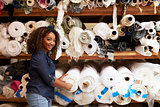 Mixed race woman selecting fabrics looking to camera