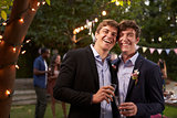 Gay Couple Celebrating Wedding With Party In Backyard