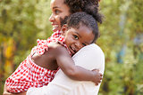 African American mother embracing with baby daughter