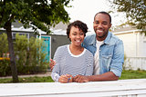 African American couple look to camera outside their house