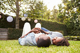 Young black couple lying on grass looking at each other