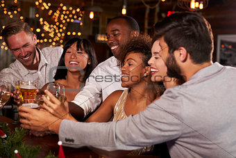 Friends at a Christmas party making a toast at the bar