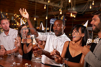 Friends uncorking champagne at a New YearÕs party at a bar