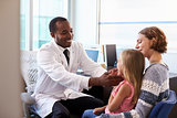 Pediatrician Examining Child In Hospital
