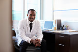 Portrait Of Doctor Wearing White Coat In Office