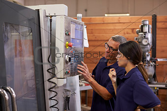 Engineer Training Female Apprentice On CNC Machine