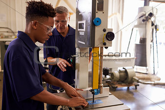 Carpenter Training Male Apprentice To Use Mechanized Saw
