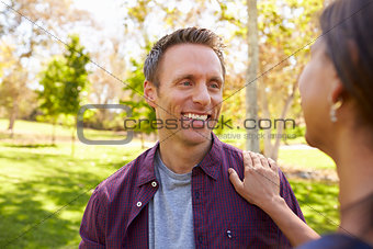 Mixed race couple in a park looking at each other