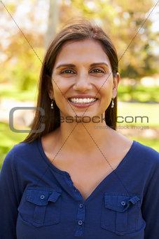 Smiling mixed race woman in park looking to camera, vertical