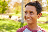 Smiling mixed race Caucasian Asian boy in park looking away