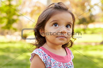 Mixed race Caucasian Asian toddler girl in a park, portrait