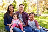Happy Asian Caucasian mixed race family, portrait in a park