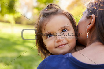 Mixed race mother holding her daughter, over shoulder view