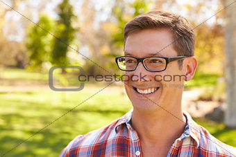 Middle aged white man wearing glasses looking away in a park