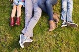 Feet of a young family lying on grass in a park, crop shot