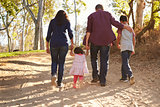 Mixed race family walking on rural path, close up back view