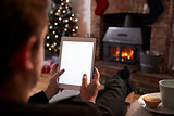 Man Using Digital Tablet In Room Decorated For Christmas