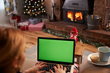 Woman Using Laptop In Room Decorated For Christmas