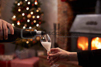 Couple Drinking Champagne In Room Decorated For Christmas