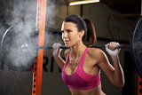 Woman In Gym Lifting Weights On Barbell