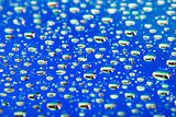 the Abstract blue background of water drops on glass with reflection green macro