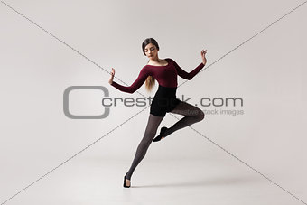 young woman dancer in maroon swimsuit posing