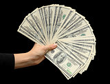 Fan of dollars in a female hand  black background