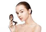 Beauty makeup model holding powder foundation