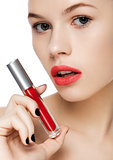 Beautiful girl holding liquid red lipstick tube