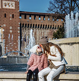 mother and daughter tourists near Sforza Castle, Milan kissing