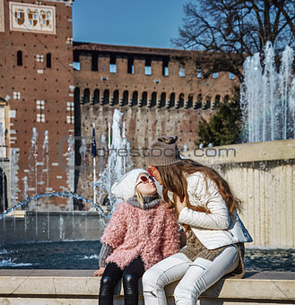 mother and daughter tourists near Sforza Castle, Milan kissing