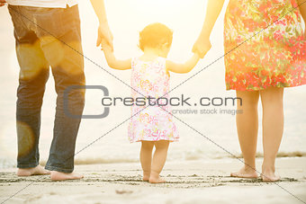Family holding hands walking on beach