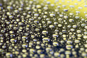 the Abstract black-yellow background with gradient color water drops on glass with reflection, bockeh, macro