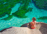 beautiful woman in bikini relaxing on the rocks over the sea. La Digue, Seychelles