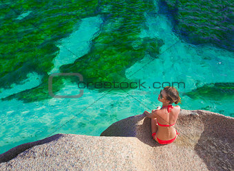 beautiful woman in bikini relaxing on the rocks over the sea. La Digue, Seychelles