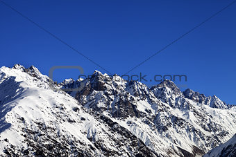 Snowy rocks and blue clear sky at cold sun day