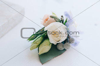 Tender rose and blue flower put in a boutonniere
