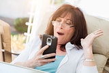 Shocked Middle Aged Woman Gasps While Using Her Smart Phone